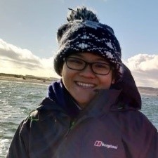 Tiff Ki in warm clothes and wearing glasses