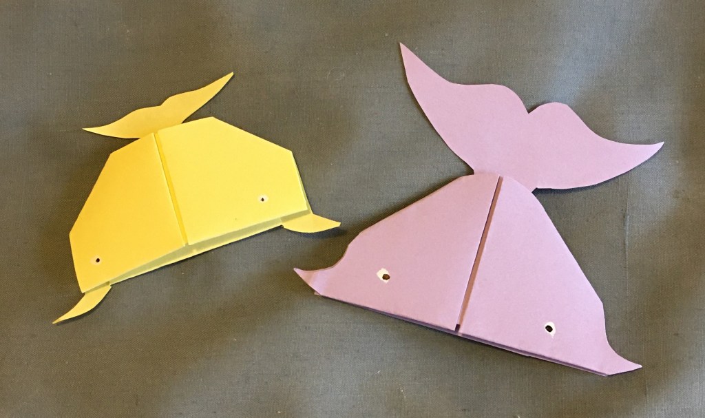 Yellow and purple whale bookmark examples showing tail shape stuck to top of origami paper whale