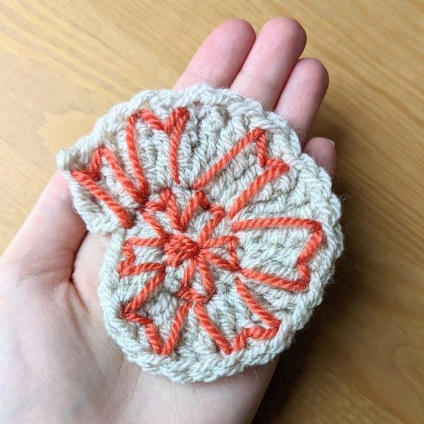 Finished nautilus with decoration in coral coloured yarn