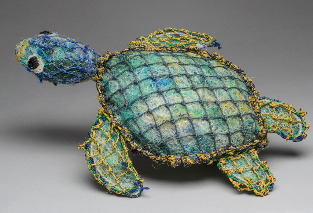 Sculpture of a turtle made from fishing nets, in shades of green, blue and yellow