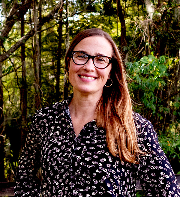 Woman standing in front of foliage