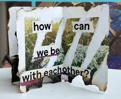 Inside of a zine with torn photo of a meadow and the words how can we be with each other